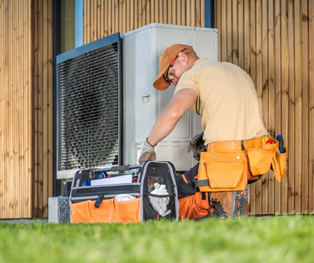 Hvac technician inspecting outdoor ac unit at a memphis home